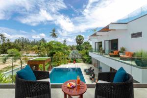 balcón con piscina y casa en Villa White Skies, en Ban Na Phong