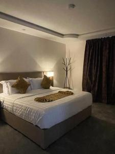 a bedroom with a large bed with white sheets at Desert Paradise Hotel فندق جنة الصحراء in Al Bad‘