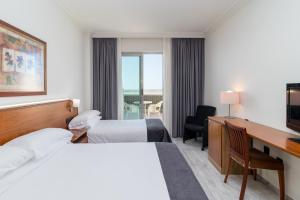a hotel room with two beds and a desk at Hotel Milagros Golf in Mogro +63 photos