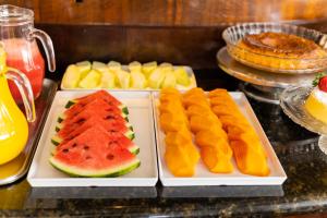 a buffet with plates of fruit on a table at Wynn Batel in Curitiba