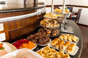 a buffet line with different types of pastries and other food at Wynn Batel in Curitiba