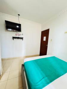 a bedroom with a bed and a television on the wall at Hotel Coco Beach Santa Marta in Santa Marta