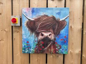 een schilderij van een bruine koe met hoorns bij Sheriffs Mountain Lodge in Derry Londonderry