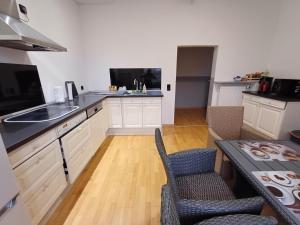 a kitchen with a sink and a table with chairs at Doppelzimmer-TV-Bad- Kühlschrank-8 in Meine