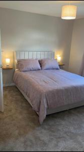 a bedroom with a large bed with two pillows at Port Miller in Portstewart