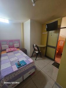 1 dormitorio con cama, mesa y TV en Su Majestad II, en Huanta