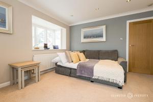 a bedroom with a bed and a table and windows at Owl Corner by Grandeur Property in Saint Leonards
