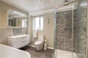 a bathroom with a toilet and a glass shower at Spacious garden apartment, sleeps 3 w/ parking - Owl Corner in Saint Leonards