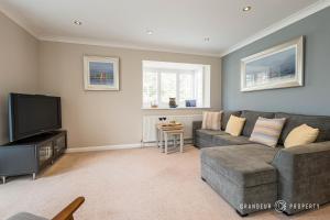 a living room with a couch and a television at Spacious garden apartment, sleeps 3 w/ parking - Owl Corner in Saint Leonards