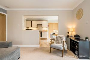 a living room with a couch and a kitchen at Owl Corner by Grandeur Property in Saint Leonards