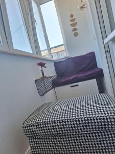 Cama en habitación con almohada morada y ventana en Apartament Central, en Vişeu de Sus