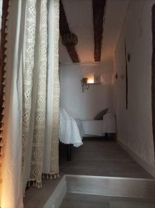 un pasillo con cortinas y una cama en una habitación en El Salero, en Villargordo del Cabriel