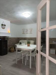 Un comedor con una mesa y sillas blancas. en El Salero, en Villargordo del Cabriel
