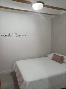 1 dormitorio con cama blanca y almohada marrón en El Salero en Villargordo del Cabriel