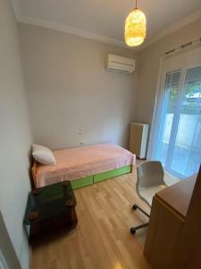 ein Schlafzimmer mit einem Bett und einem Stuhl darin in der Unterkunft Cozy Apartment in Cholargos in Athen
