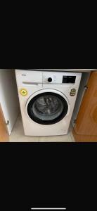 una lavadora blanca en una habitación en MFC konaklama, en Yeşilyurt