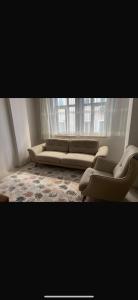 une chambre avec un canapé, des chaises et une fenêtre dans l'établissement MFC konaklama, à Yeşilyurt