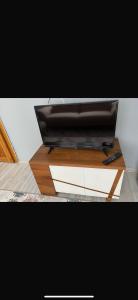 - une télévision installée au-dessus d'une table en bois dans l'établissement MFC konaklama, à Yeşilyurt
