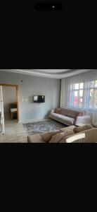 - un salon avec un grand lit et un canapé dans l'établissement MFC konaklama, à Yeşilyurt