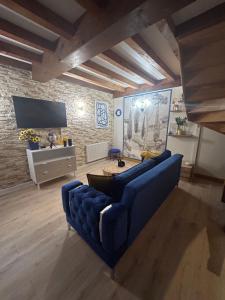 a living room with a blue couch and a tv at Appart hôtel le 8 La Suite - parking gratuit - in Mâcon
