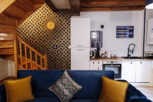 a living room with a blue couch and a kitchen at Appart hôtel le 8 La Suite - parking gratuit - in Mâcon