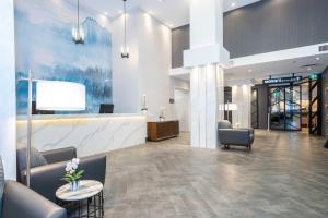 a lobby with a waiting room with chairs and a counter at Sandman Signature Calgary Downtown Hotel in Calgary