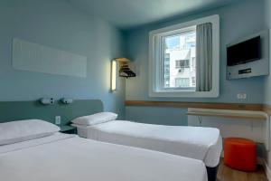 a hospital room with two beds and a window at ibis budget RJ Praia de Botafogo in Rio de Janeiro +54 photos