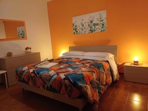 1 dormitorio con 1 cama con un edredón colorido en Casa Ester, en Passo Corese