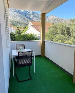 a table and chair on a balcony with a view at Apartments Vero Orebic 1 in Orebić +1 photo