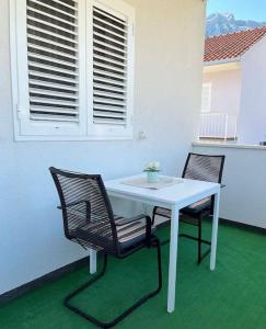 a white table and two chairs on a balcony at Apartments Vero Orebic 1 in Orebić