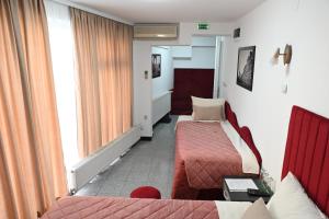 une chambre d'hôtel avec deux lits et un canapé dans l'établissement Apartments Imper - IMD, à Niš