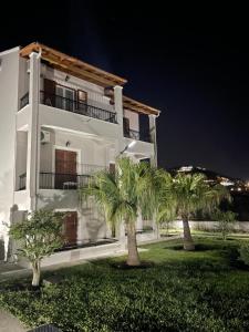 a white building with two palm trees in front of it at Casa Alema Verde in Ýpsos +22 photos