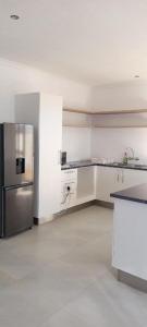 an empty kitchen with a stainless steel refrigerator at Bon Sejour Guesthouse in Okakarara