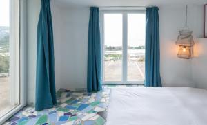 a bedroom with a bed and a large window at Casa Tiberius Capri Retreat by Sweet Capri in Capri