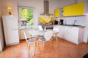 a kitchen with a table and chairs and a kitchen with yellow cabinets at Seeblick in Stuer +12 photos