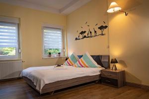 - une chambre avec un lit et un mur orné d'oiseaux dans l'établissement Seeblick, à Stuer