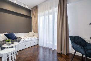 Schlafzimmer mit einem Bett, einem Tisch und Stühlen in der Unterkunft Three Bedrooms Apartment in Bukarest