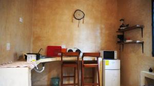 une cuisine avec une table, des chaises et un réfrigérateur dans l'établissement TulummiLucha, à Tulum