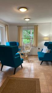 a living room with blue chairs and a glass table at Agroturystyka Dom Wśród Sosen in Rzędkowice