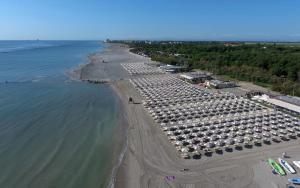 una vista aérea de una playa con un montón de coches aparcados en Appartamento dei Pavoni, en Punta Marina