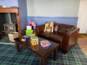 sala de estar con sofá de cuero y mesa de centro en Decker’s en Leven-Fife