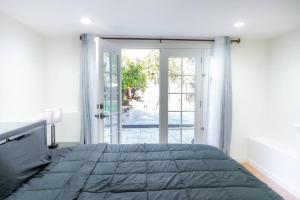 een slaapkamer met een groot bed en een glazen schuifdeur bij Villa Palo Alto in East Palo Alto