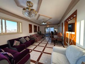 a living room with purple couches and a table at 3BR Apartment on Plage in Dawwār ‘Abd Allāh