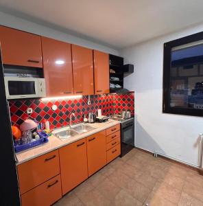 a small kitchen with orange cabinets and a sink at Blue Orange Lake Hostel in Ohrid