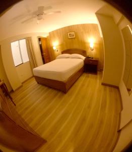kreisförmiges Zimmer mit einem Bett und Holzboden in der Unterkunft Hotel Asturias Inn in Lima