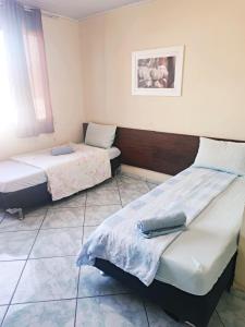 Habitación con 2 camas y una foto en la pared. en Hotel Ita, en Itaboraí
