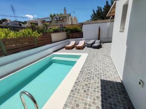 a small swimming pool in a backyard with a house at Amphitrite Beach House in Agios Nikolaos
