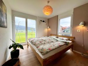 1 dormitorio con cama y ventana grande en Spacieuse maison avec jardin, en Savagnier