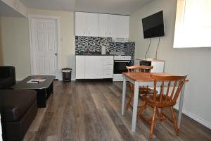 cocina y sala de estar con mesa y sillas en Metropolitan Suite, en Niagara Falls