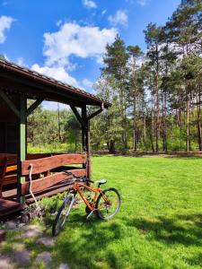 una bicicleta estacionada junto a un banco en un campo en Pożarowo domek na mazowszu, en Królewo